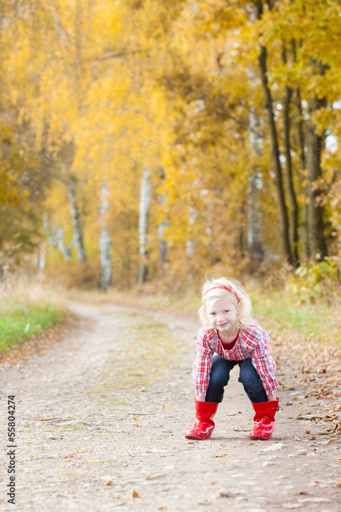 little girl wearing rubber boots in autumnal alley little girl wearing rubber boots in autumnal alley