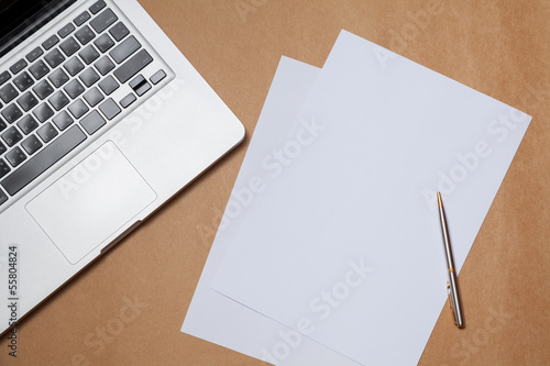 blank paper and laptop on table