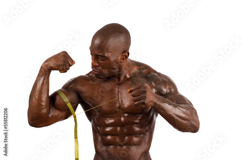 Black bodybuilder taking measurements of his big muscles