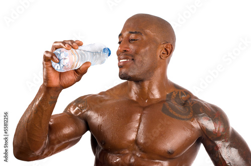 Black bodybuilder drinking water after a hard workout