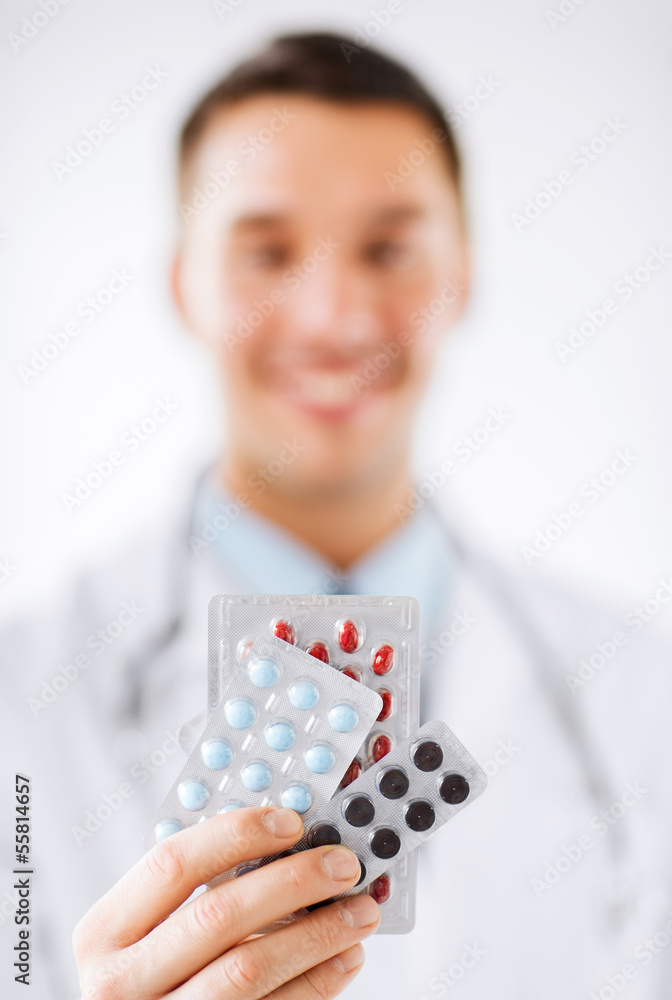 male doctor with packs of pills