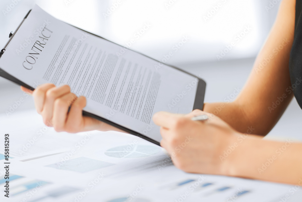woman hand signing contract paper woman hand signing contract paper