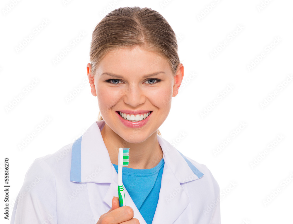 Smiling woman dentist showing tooth brush, isolated Smiling woman dentist showing tooth brush, isolated
