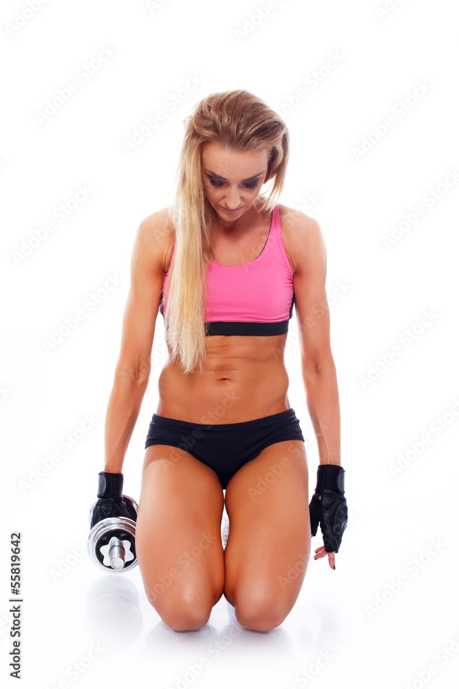 Sporty woman with dumbbell standing on her knees Sporty woman with dumbbell standing on her knees