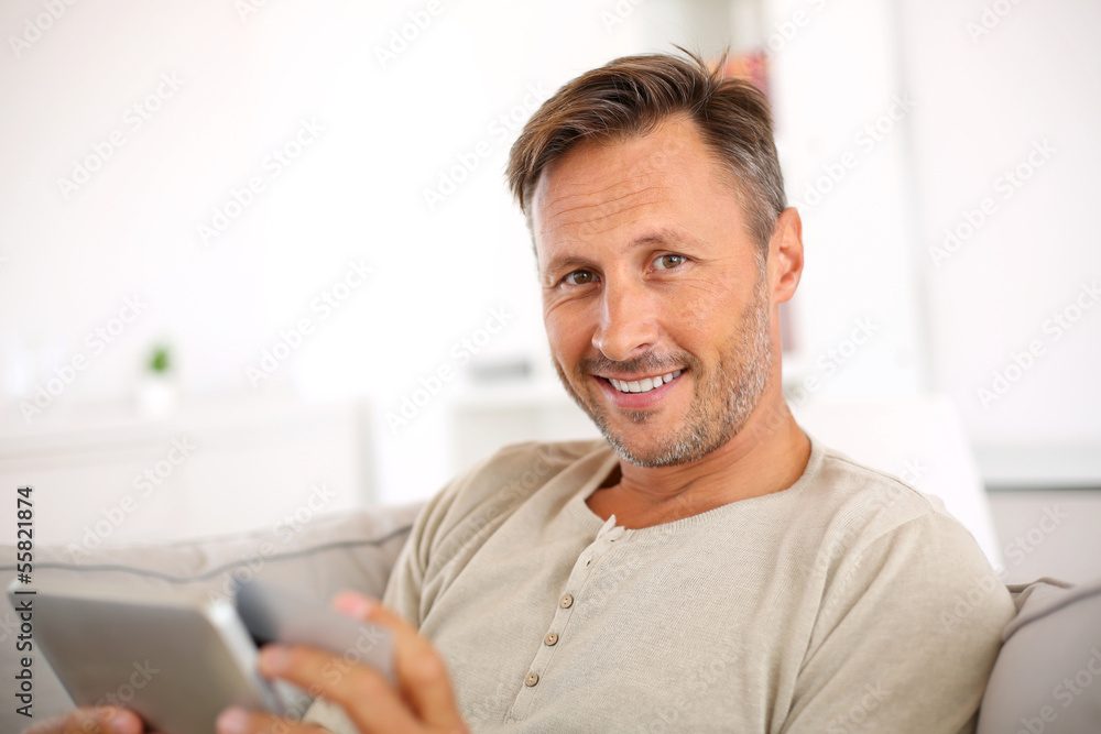 Handsome smiling man at home buying on internet Handsome smiling man at home buying on internet