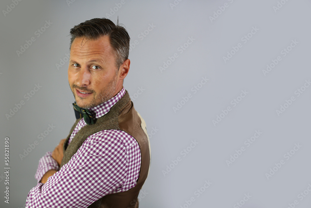 Obraz premium Smiling trendy guy with bowtie on white background