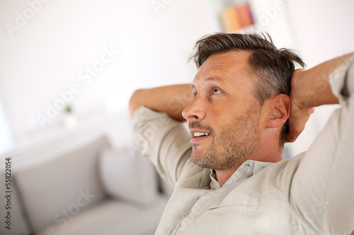 Man relaxing with outstretched arms behind head