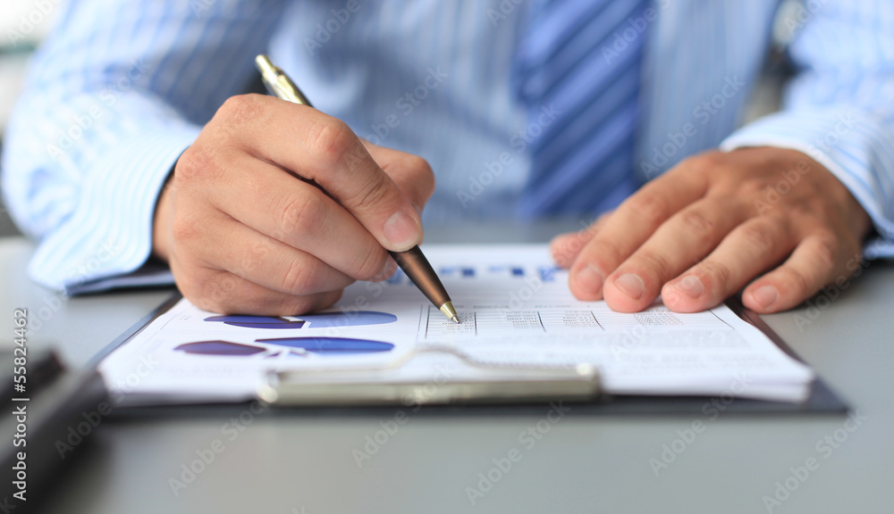 Close-up of graphs and charts analyzed by businessman Close-up of graphs and charts analyzed by businessman