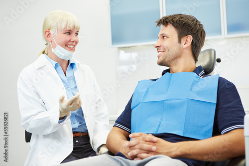 Dentist talking with patient on chair