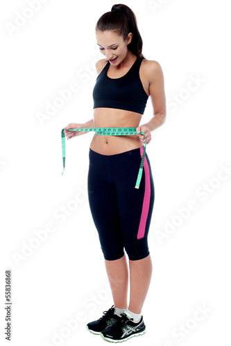 Slim fit woman measuring her waist © stockyimages