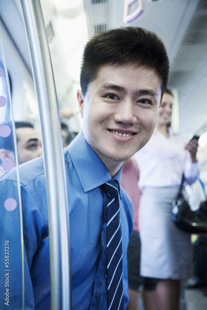 Portrait of young businessman sitting on the subway and looking at the camera Portrait of young businessman sitting on the subway and looking at the camera