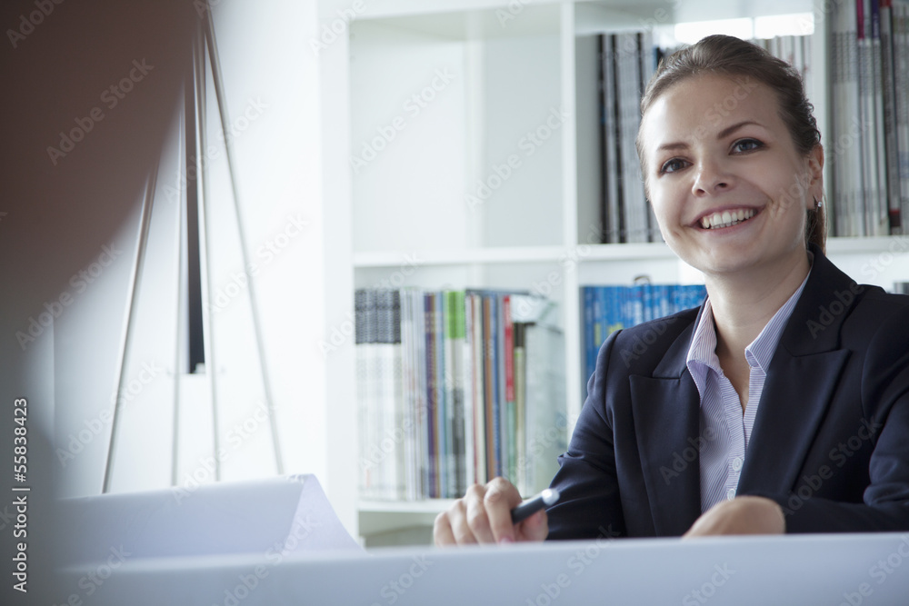 Young businesswoman smiling in the office during a business meeting Young businesswoman smiling in the office during a business meeting