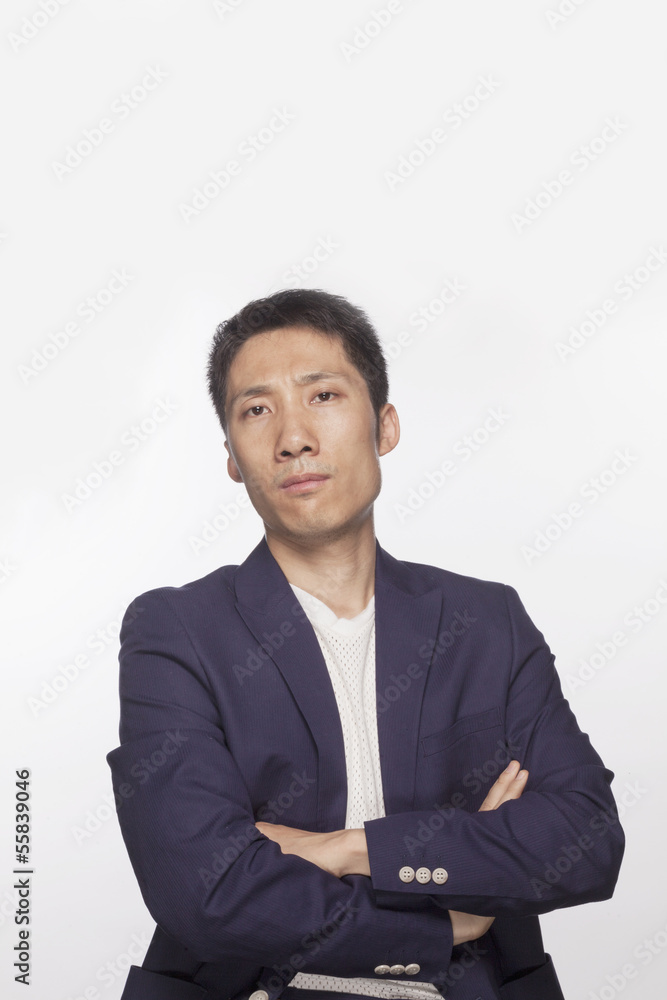 Portrait of serious man with arms crossed looking at camera, studio shot Portrait of serious man with arms crossed looking at camera, studio shot