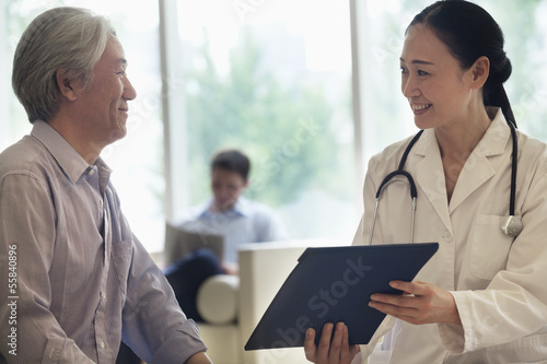 Photography Female doctor and patient sitting down and discussing medical record in the hosp