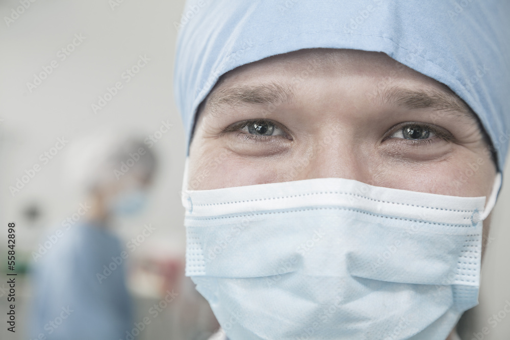 Portrait of surgeon with surgical mask and surgical cap in the operating room Portrait of surgeon with surgical mask and surgical cap in the operating room