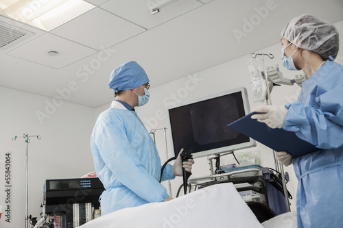 Obraz na płótnie Two surgeons preparing for surgery, patient lying down