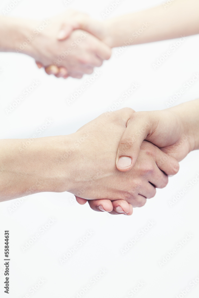 Four young people shaking hands, close-up, studio shot Four young people shaking hands, close-up, studio shot
