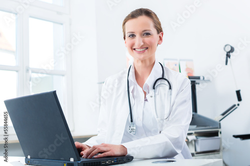 Female doctor writing on Pc in her clinic