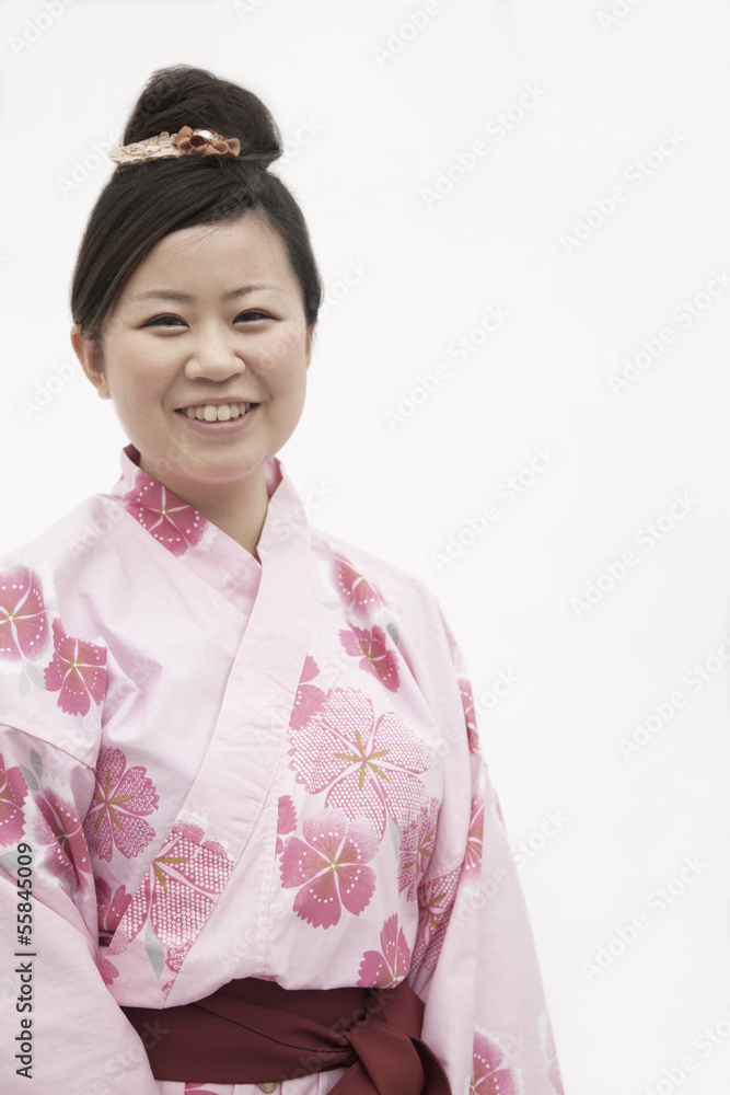 Portrait of young smiling woman in a pink Japanese kimono, studio shot Portrait of young smiling woman in a pink Japanese kimono, studio shot