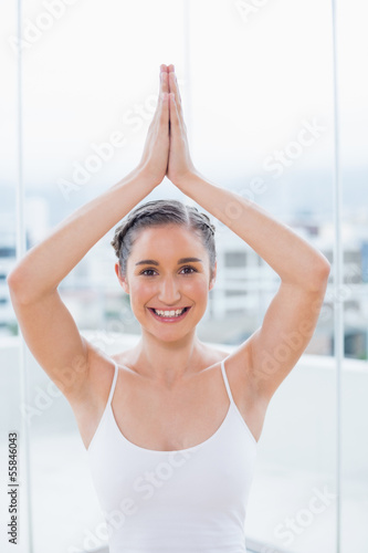 Cheerful sporty brunette sitting in yoga posture