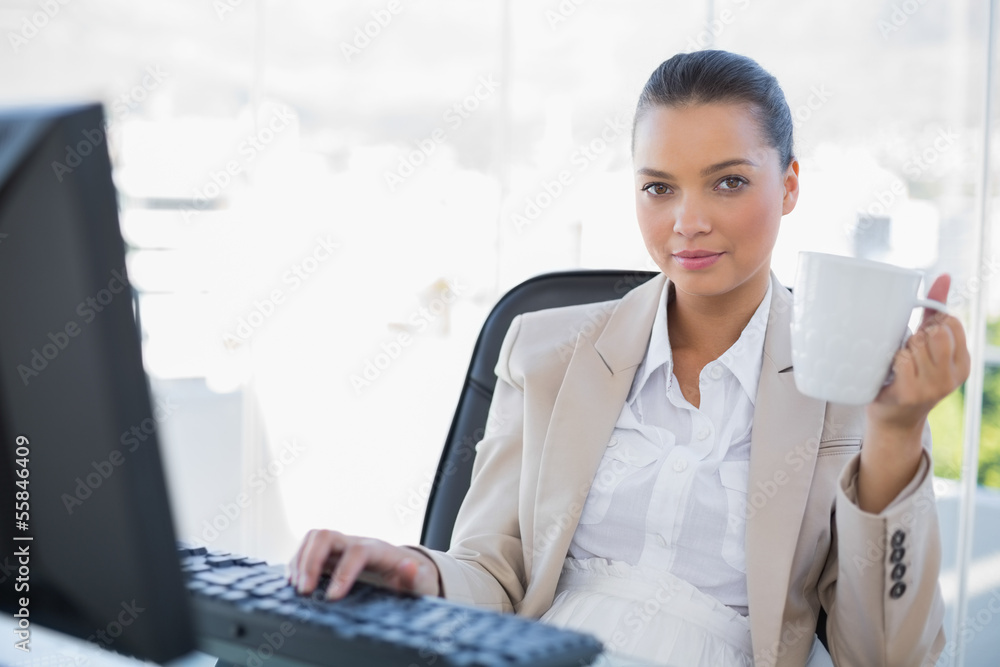 Relaxed businesswoman holding coffee looking at camera Relaxed businesswoman holding coffee looking at camera
