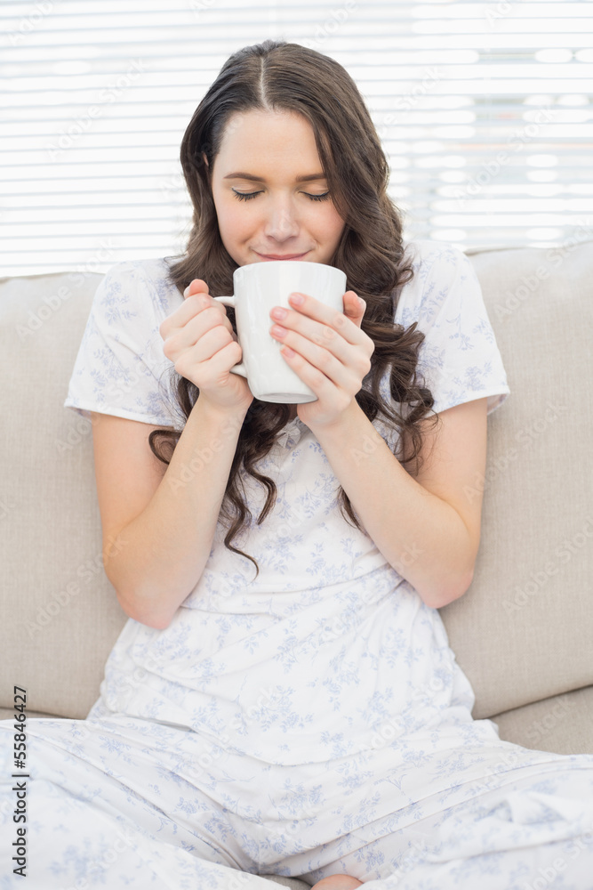 Relaxed young woman in pyjamas having coffee Relaxed young woman in pyjamas having coffee