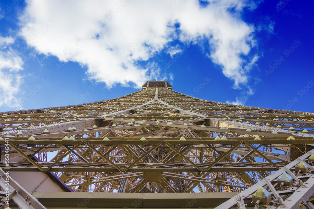 Eiffel tower under clouds and blue sky