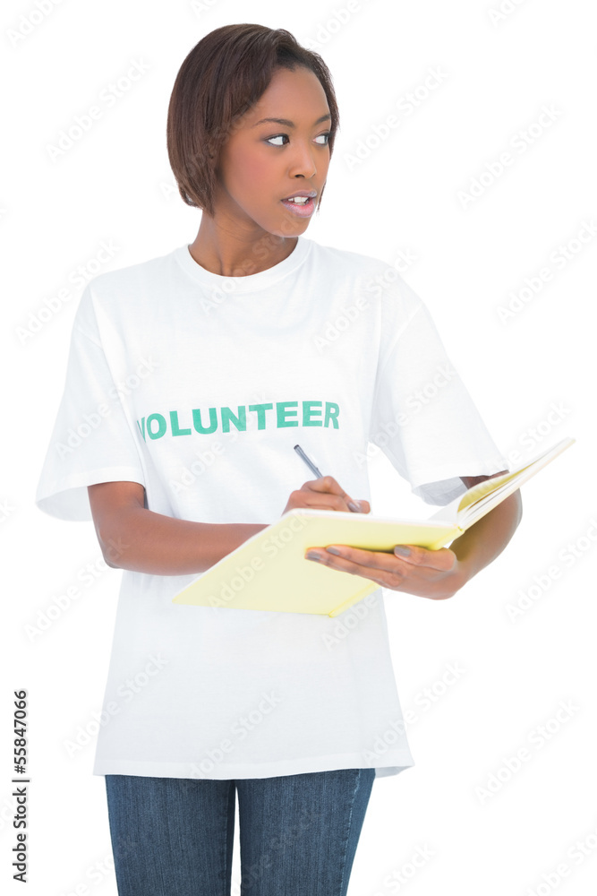 Pretty volunteer woman writing on notebook Pretty volunteer woman writing on notebook