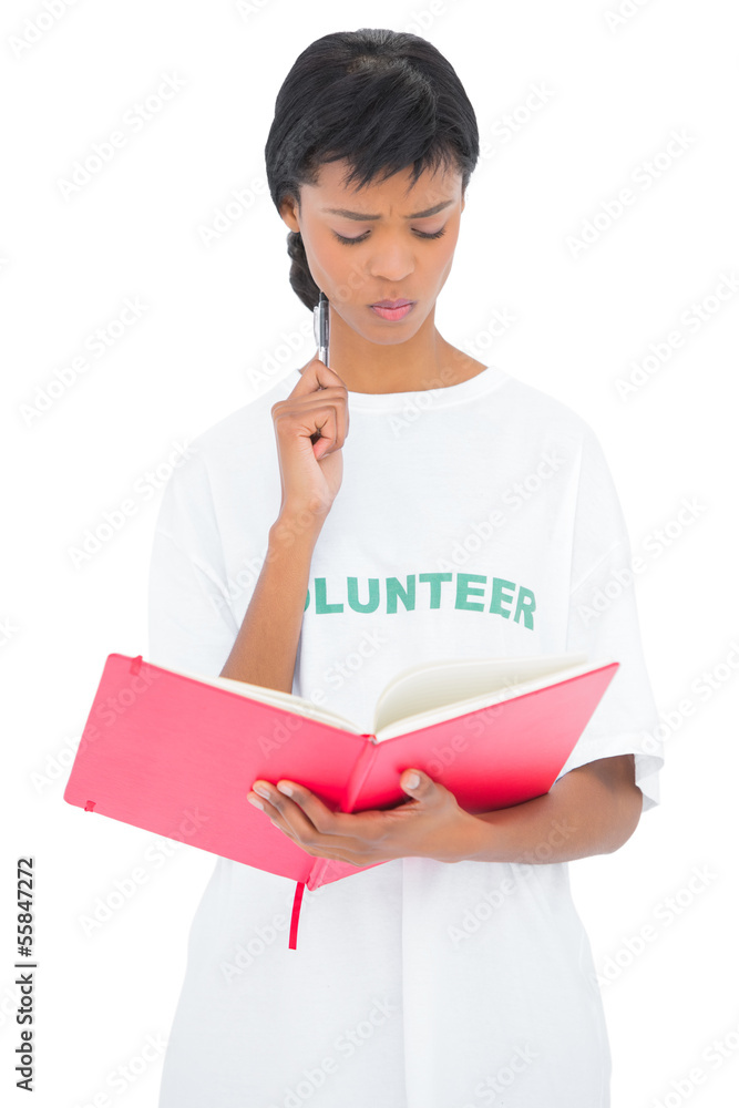 Pensive black haired volunteer looking at a notebook Pensive black haired volunteer looking at a notebook