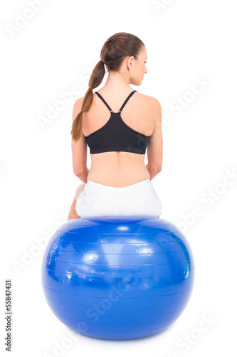 Rear view of fit woman sitting on exercise ball