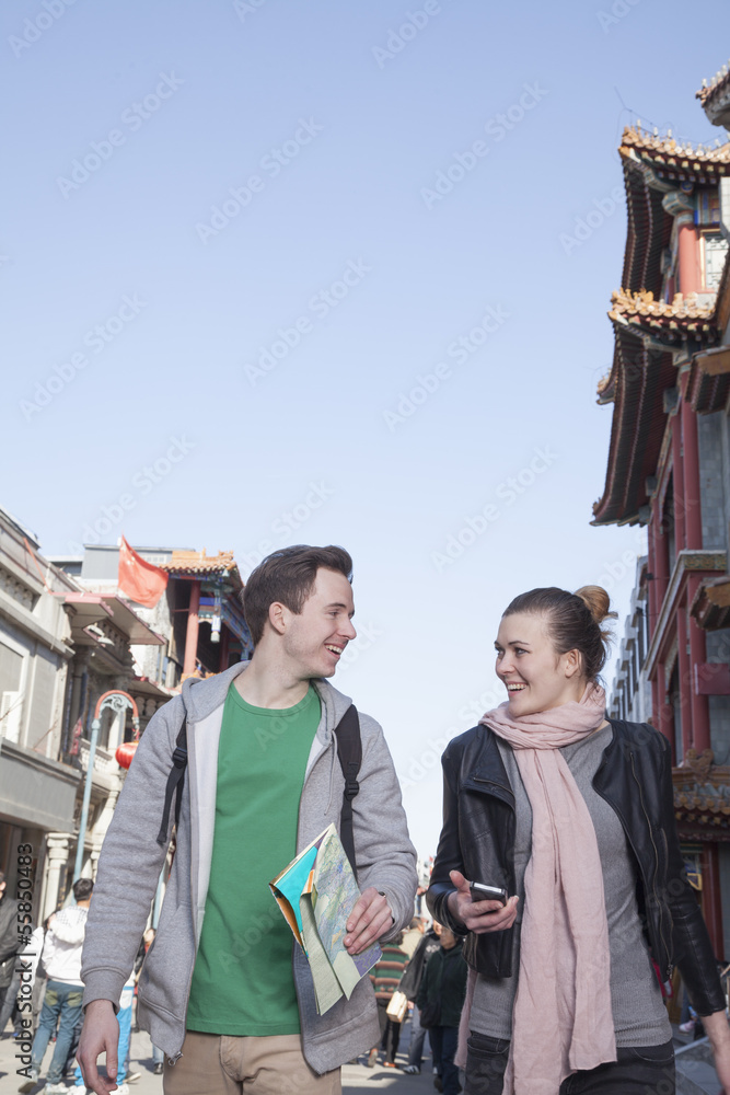 Young couple sightseeing, holding map and mobile phone. Young couple sightseeing, holding map and mobile phone.
