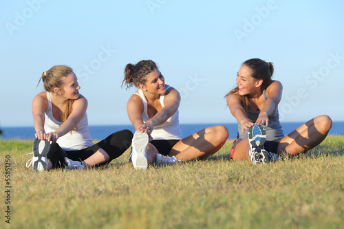 Group of three women stretching after sport