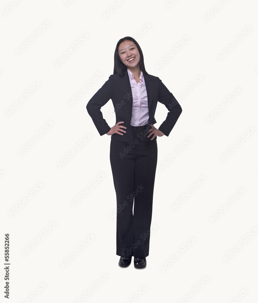 Portrait of smiling young businesswoman with hands on hips looking at camera, full length, studio shot Portrait of smiling young businesswoman with hands on hips looking at camera, full length, studio shot