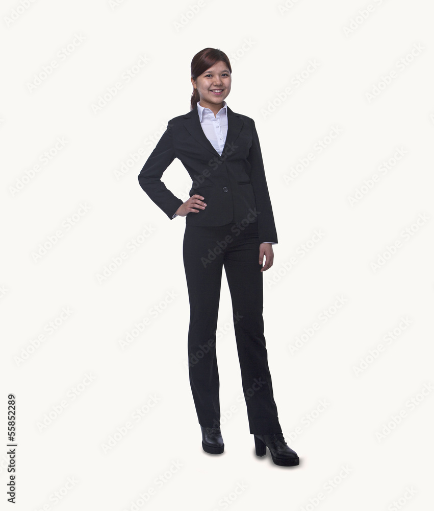 Portrait of smiling young businesswoman with hand on hip looking at camera, full length, studio shot Portrait of smiling young businesswoman with hand on hip looking at camera, full length, studio shot