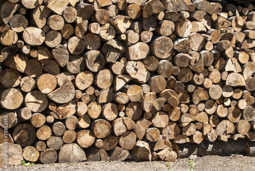 Stacked oak firewood in countryside as background