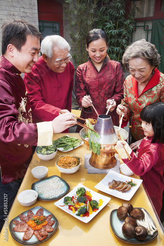 Family enjoying Chinese meal in traditional Chinese clothing