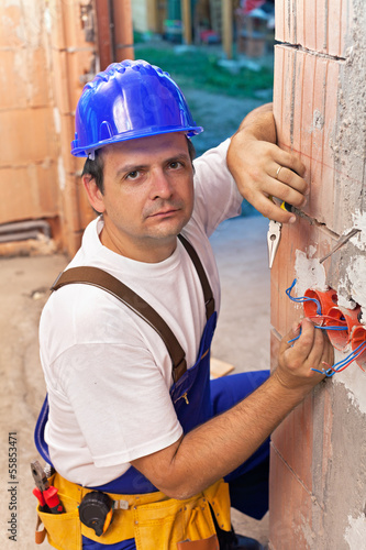 Electrician installing wires in a new building