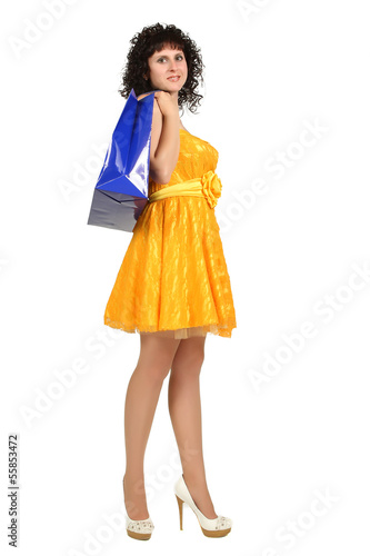brunette in a yellow dress with shopping bags