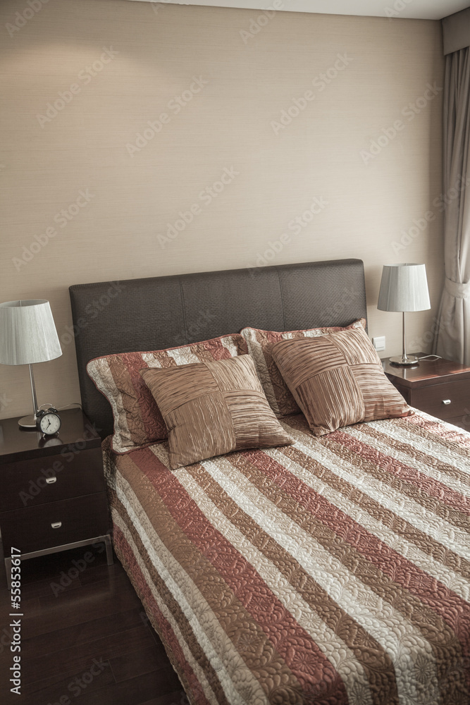 Fototapeta premium Bright, modern bedroom with striped bedspread. 