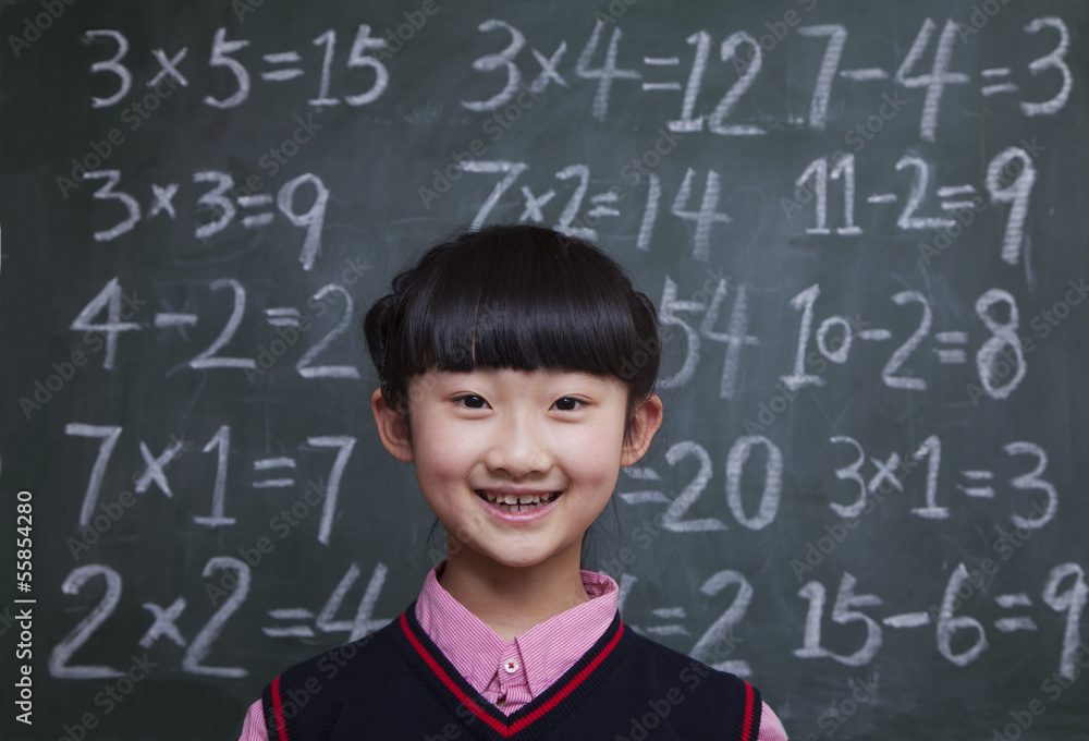 Portrait of schoolgirl in front of blackboard with math equations Portrait of schoolgirl in front of blackboard with math equations