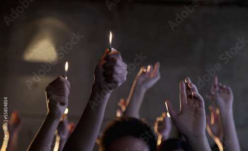 Group of people holding cigarette lighters at a concert