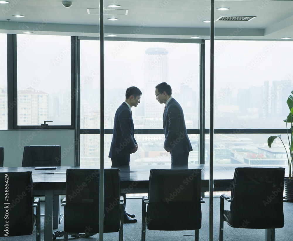 Two Businessmen Bowing to Each Other Two Businessmen Bowing to Each Other