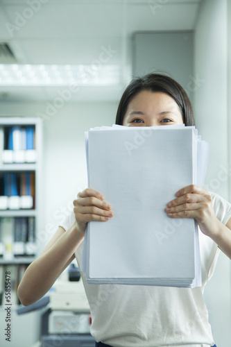 Businesswoman Hiding Behind Paper