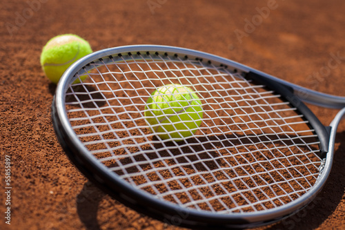 Tennis balls and racket on field © BrunoWeltmann