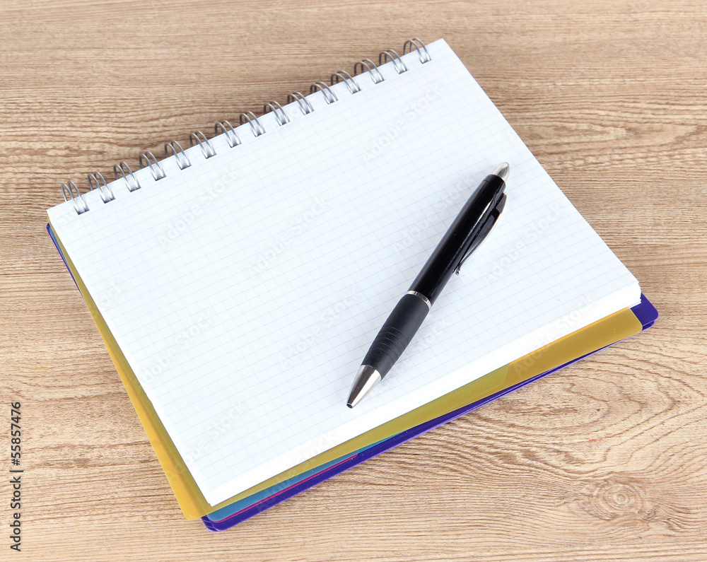Notebook and pen on wooden table Notebook and pen on wooden table