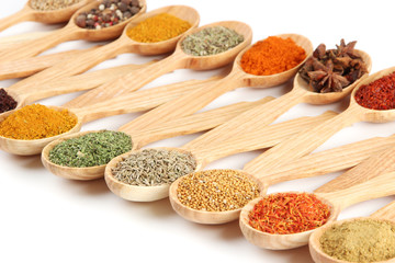 Fototapete Gewürze Assortment of spices in wooden spoons, isolated on white  © Africa Studio
