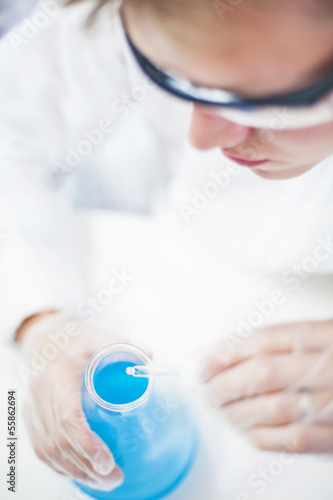 Chemist in laboratory mixing fuild with eyedropper