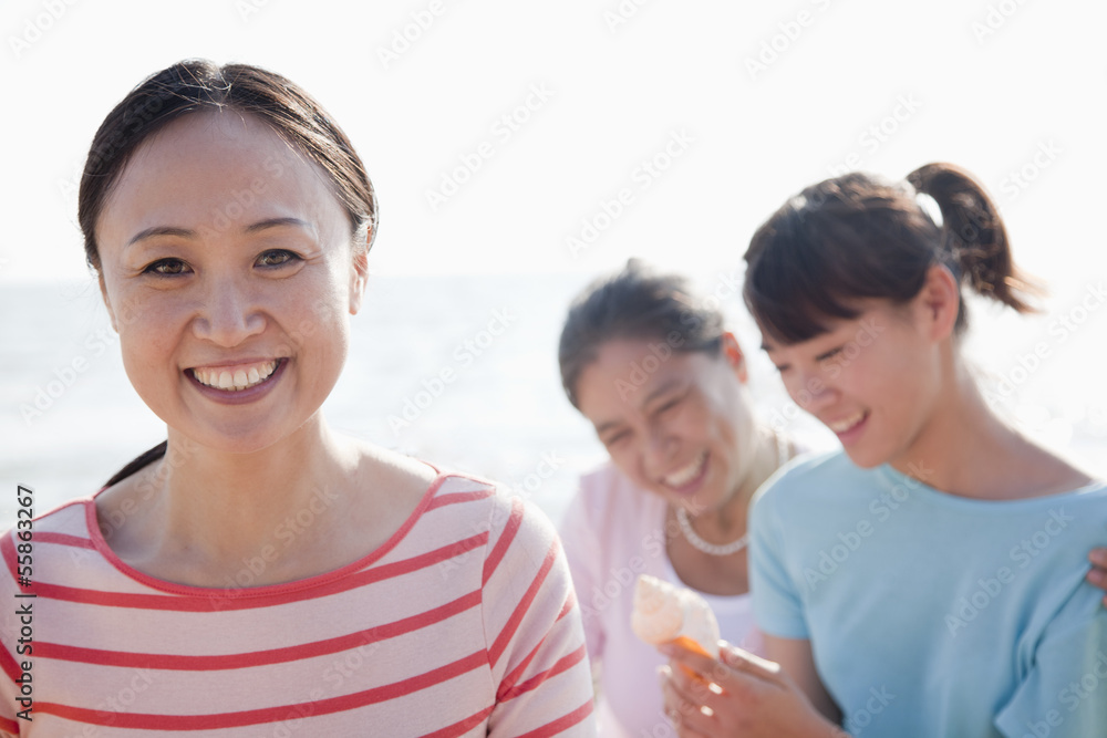 Portrait of multi- generational family on the beach, looking at Shell Portrait of multi- generational family on the beach, looking at Shell
