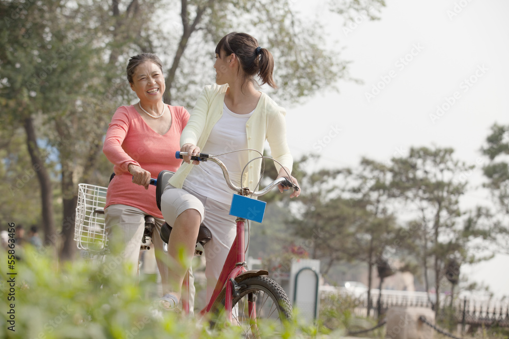 Grandmother and granddaughter riding tandem bicycle, Beijing Grandmother and granddaughter riding tandem bicycle, Beijing