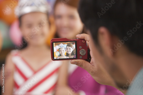 Father Taking a Picture of Mother and Daughter on Daughter's Birthday